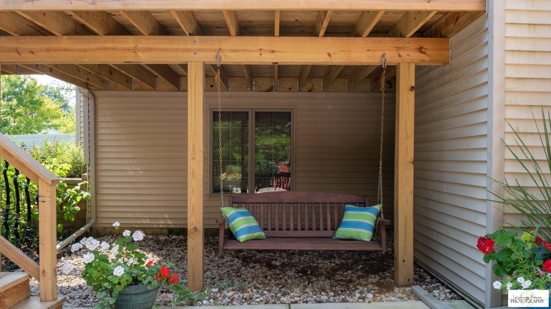 A porch with a swing hanging from the ceiling.