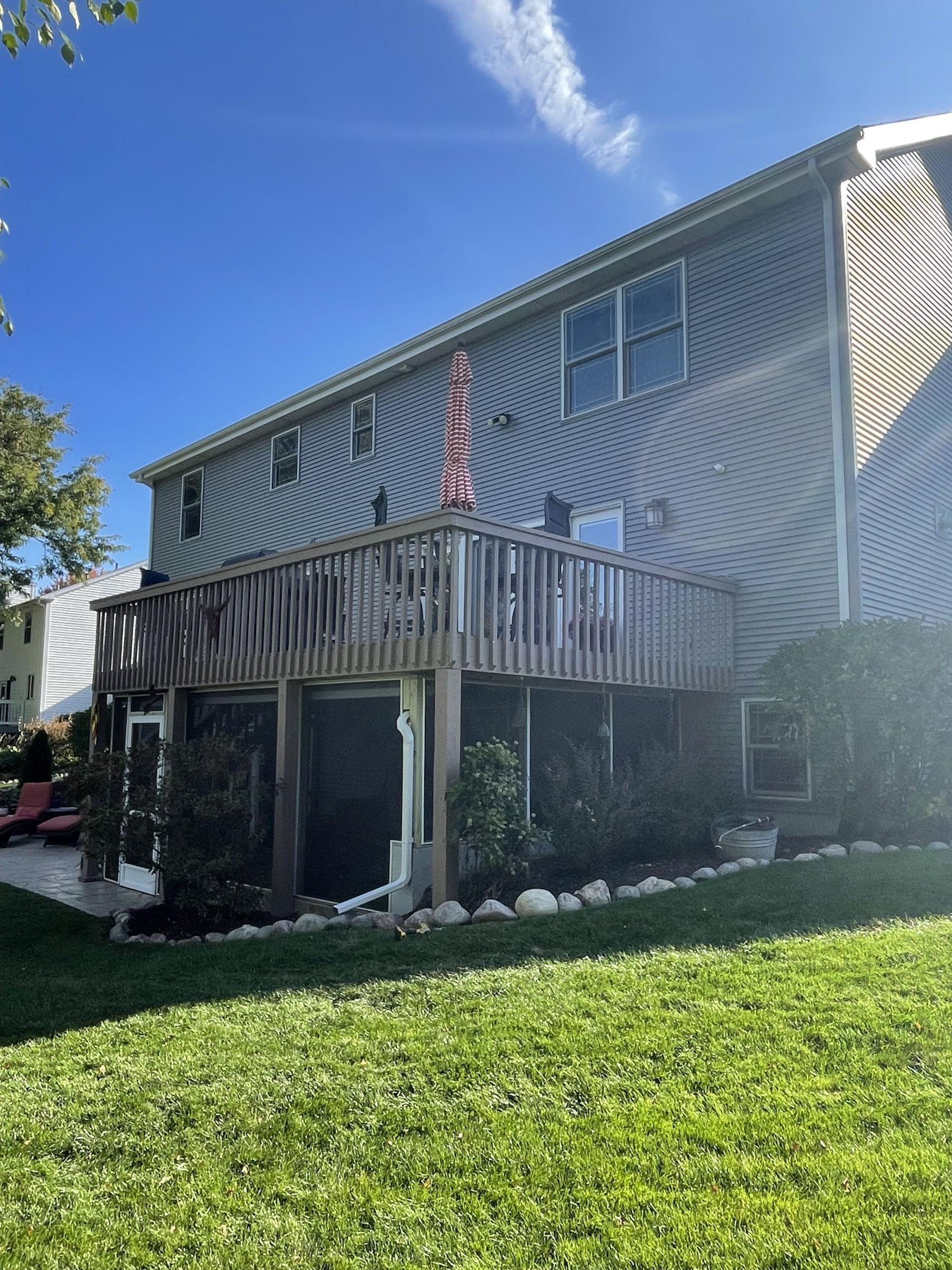 A large house with a large deck in the backyard.