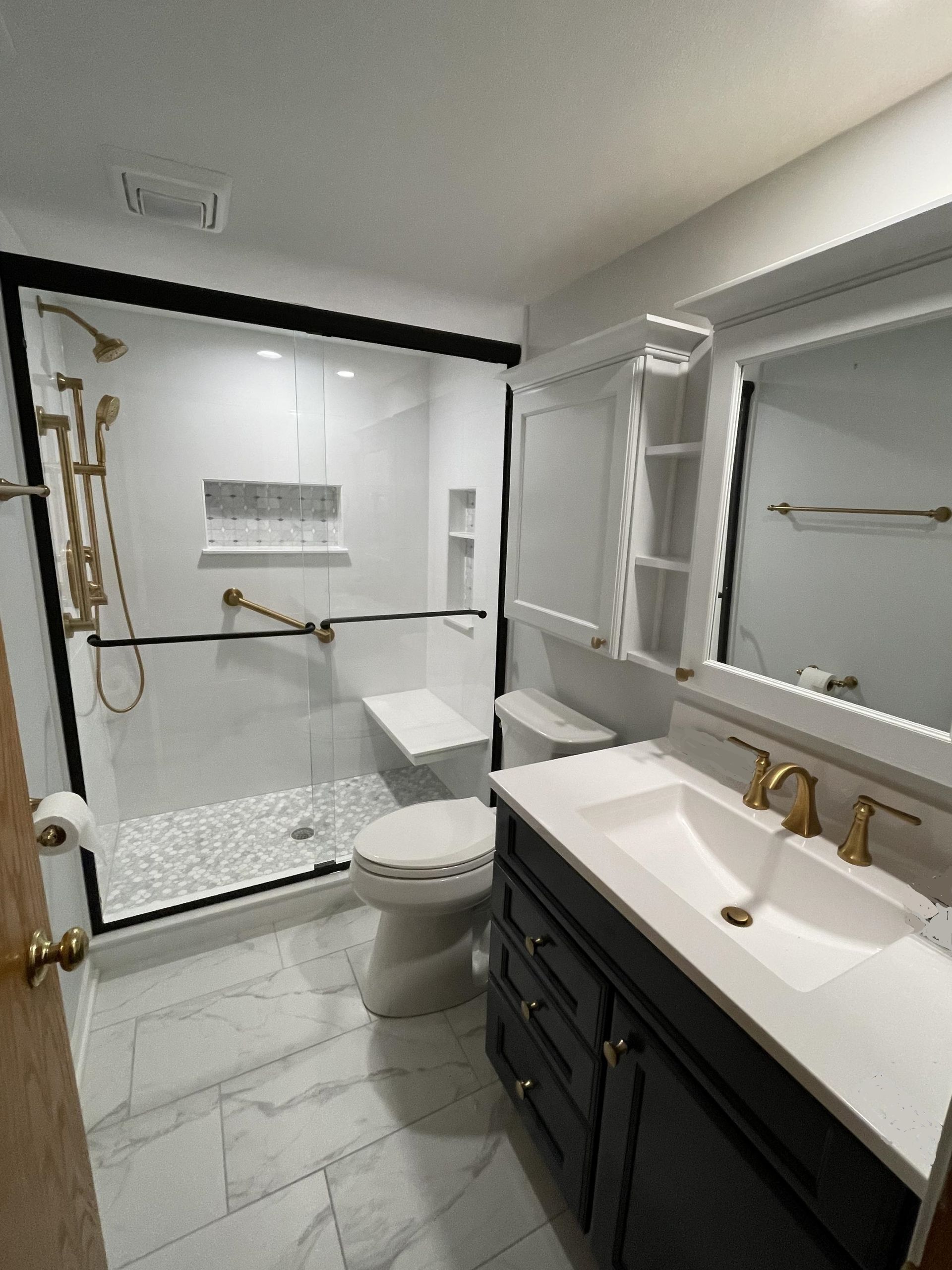 A bathroom with a sink , toilet , shower and mirror