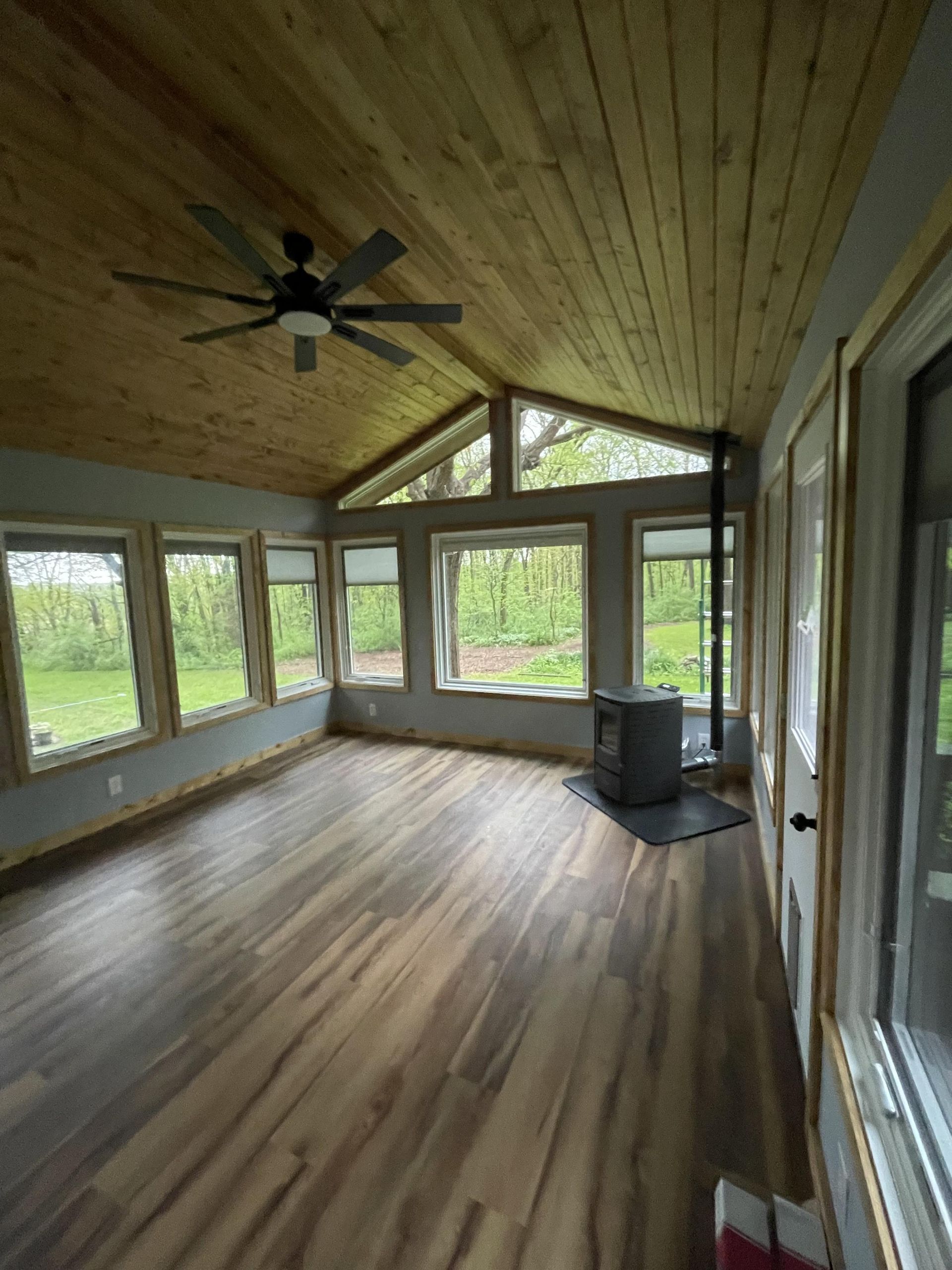 A living room with hardwood floors and a ceiling fan.