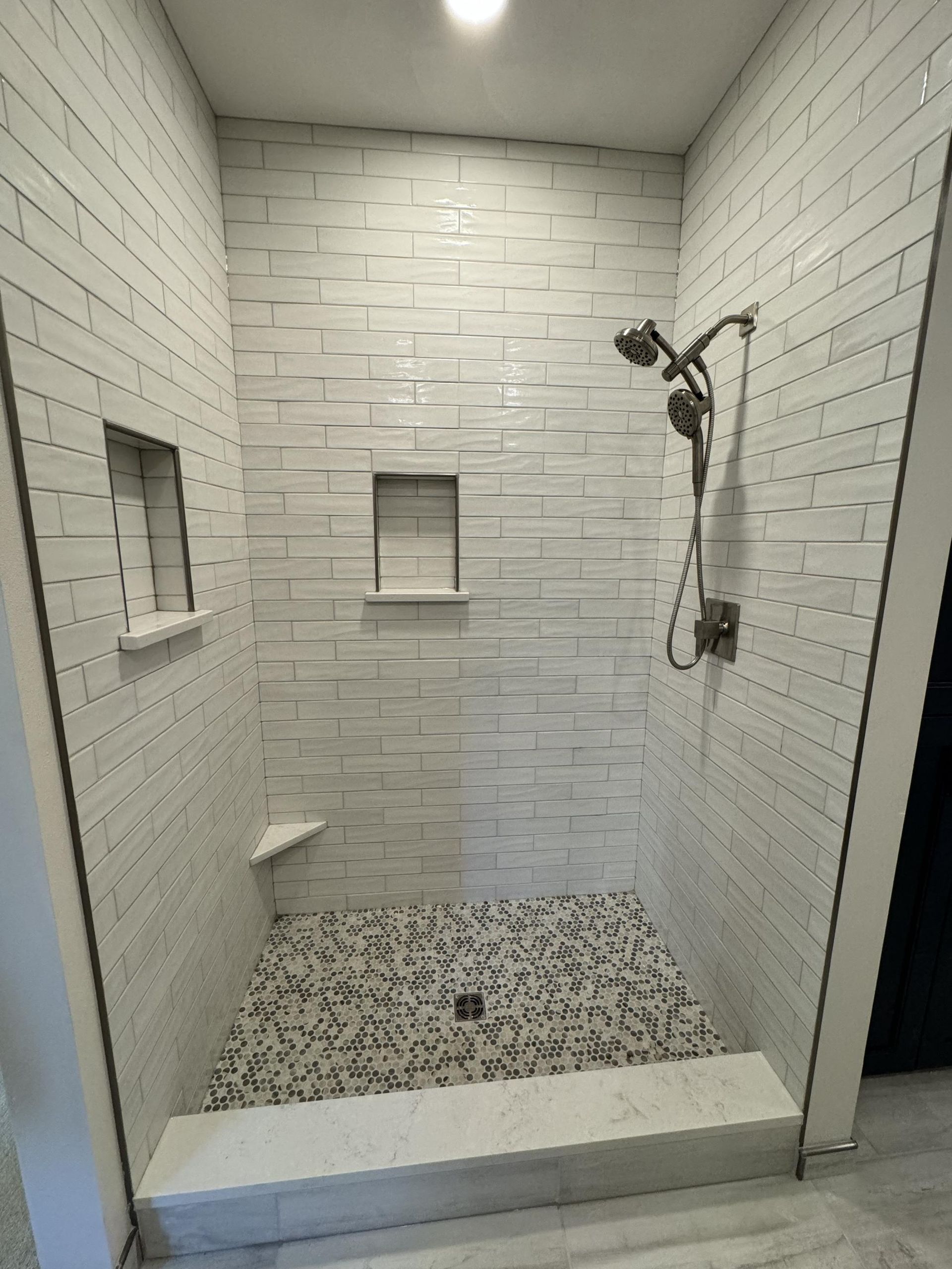 A bathroom with a walk in shower and a shower head.