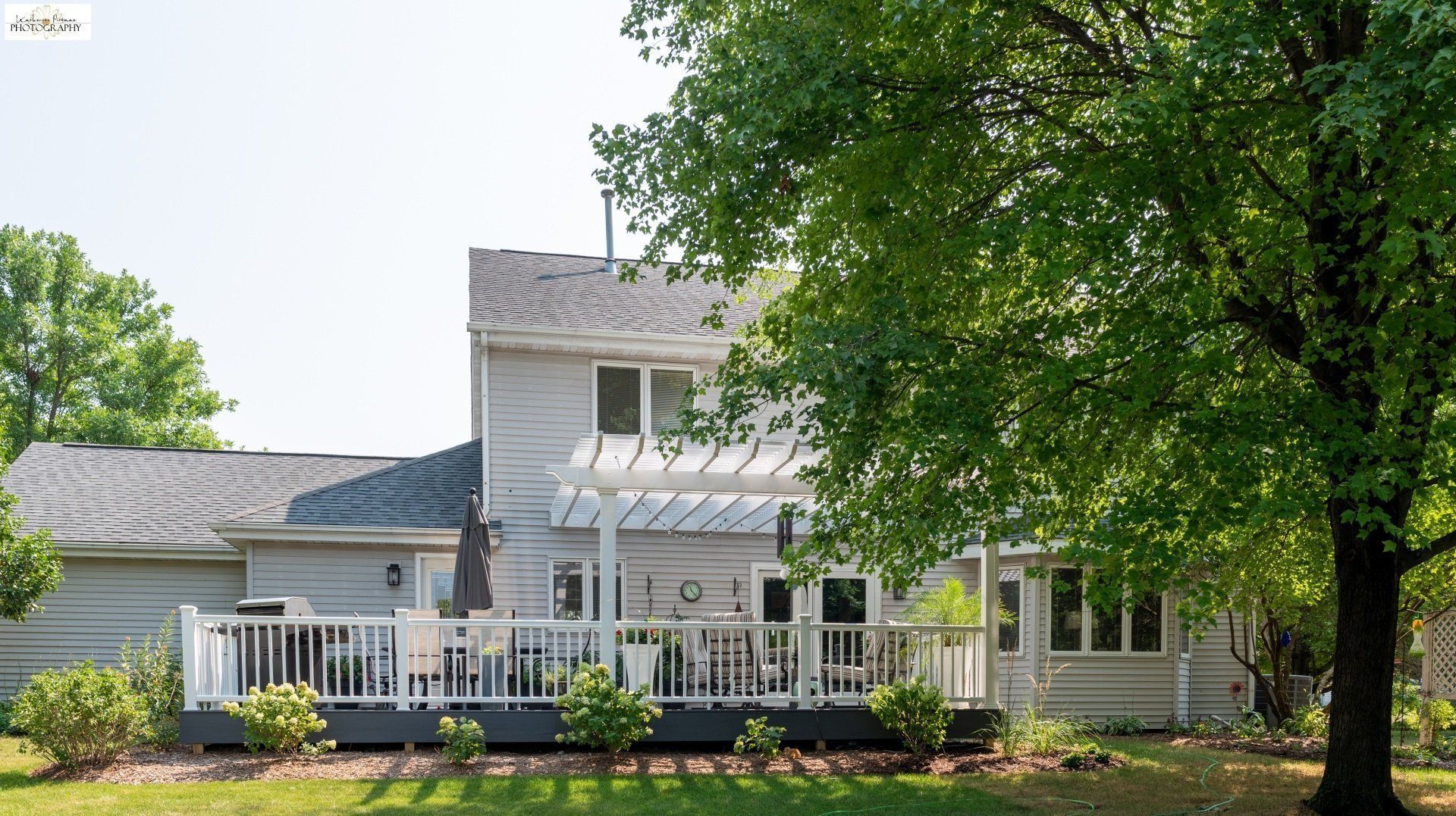 The back of a house with a large deck and a pergola.