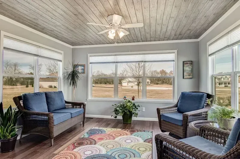 A living room with a couch , chairs , and a ceiling fan.