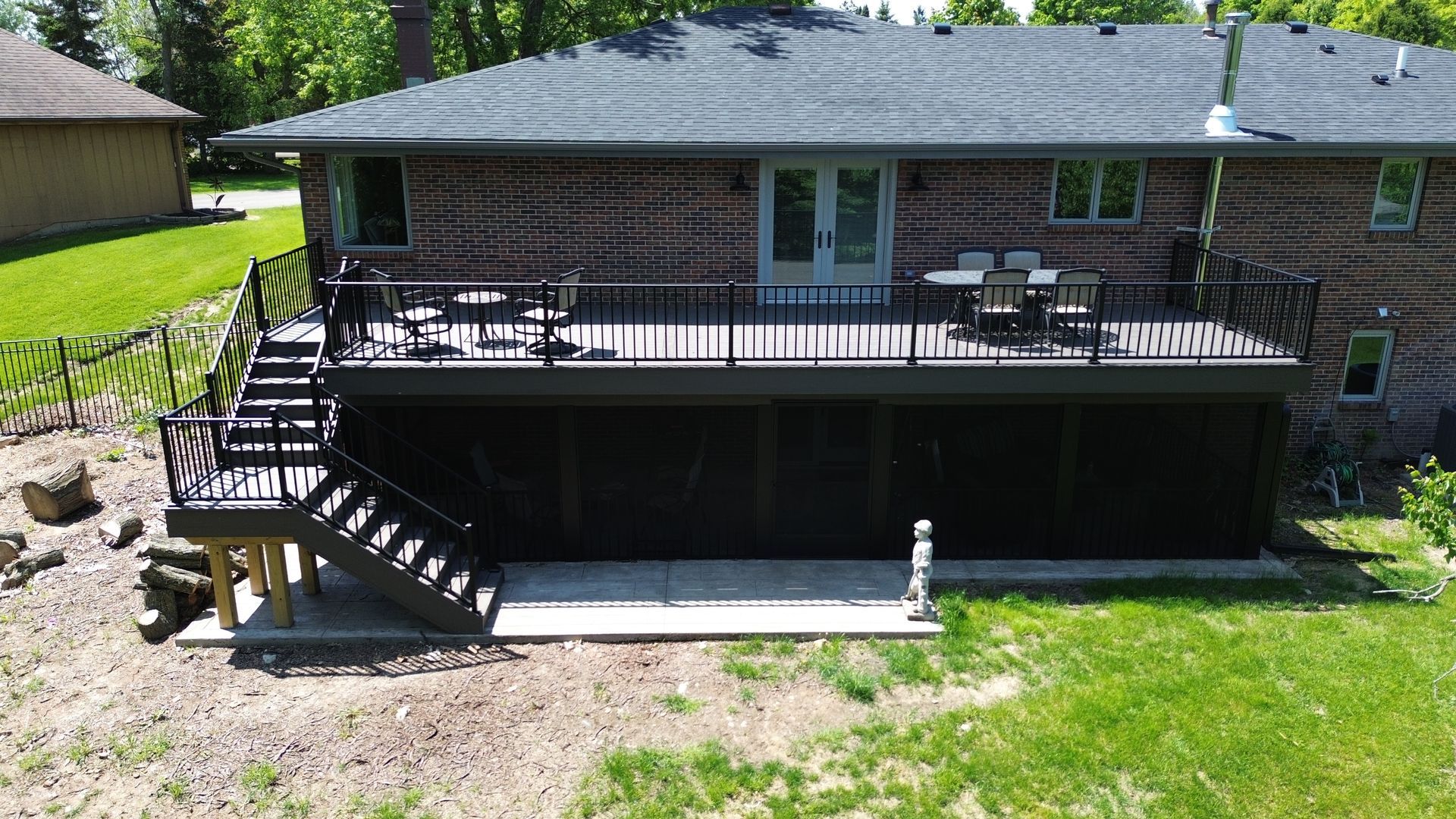 An aerial view of a house with a large deck and stairs.