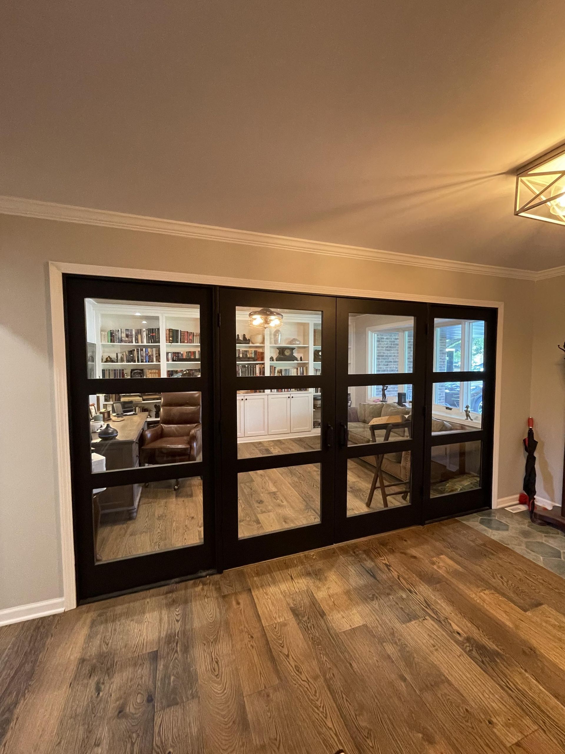 A living room with a lot of windows and a wooden floor.
