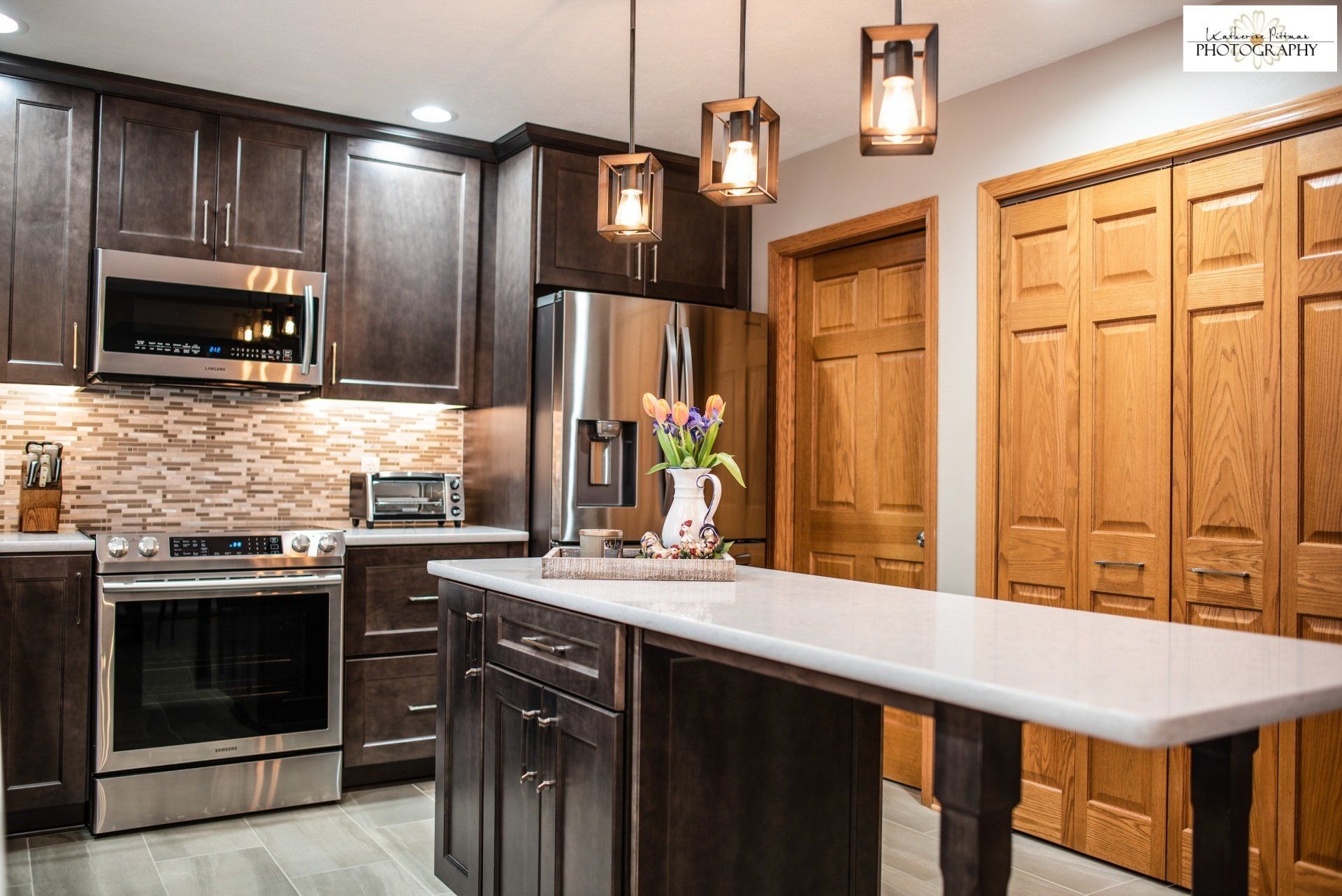 A kitchen with stainless steel appliances , wooden cabinets , and a large island.