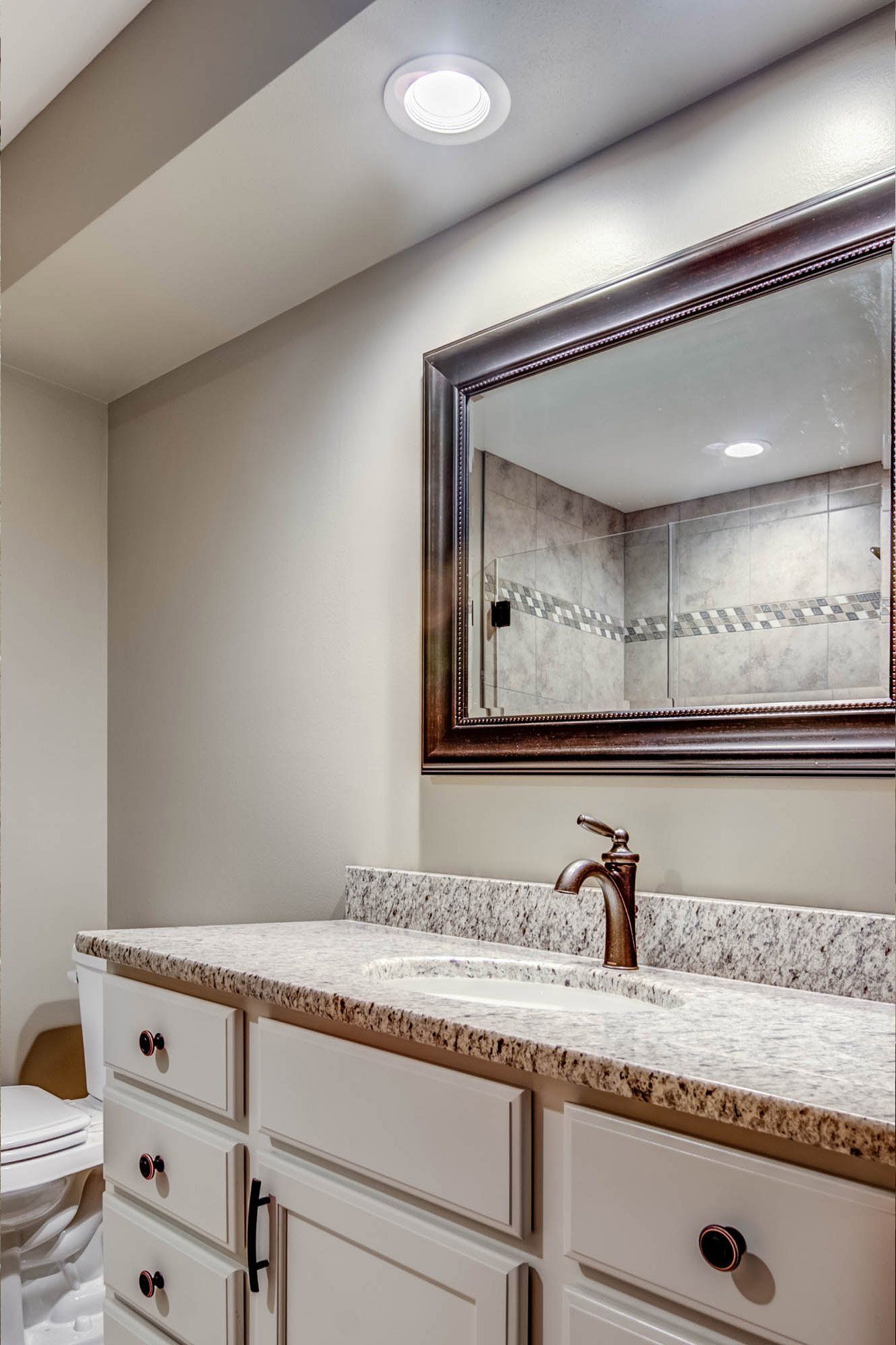 A bathroom with a sink , toilet and mirror.