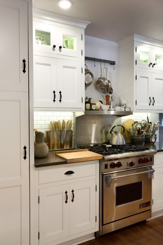 A kitchen with stainless steel appliances and white cabinets
