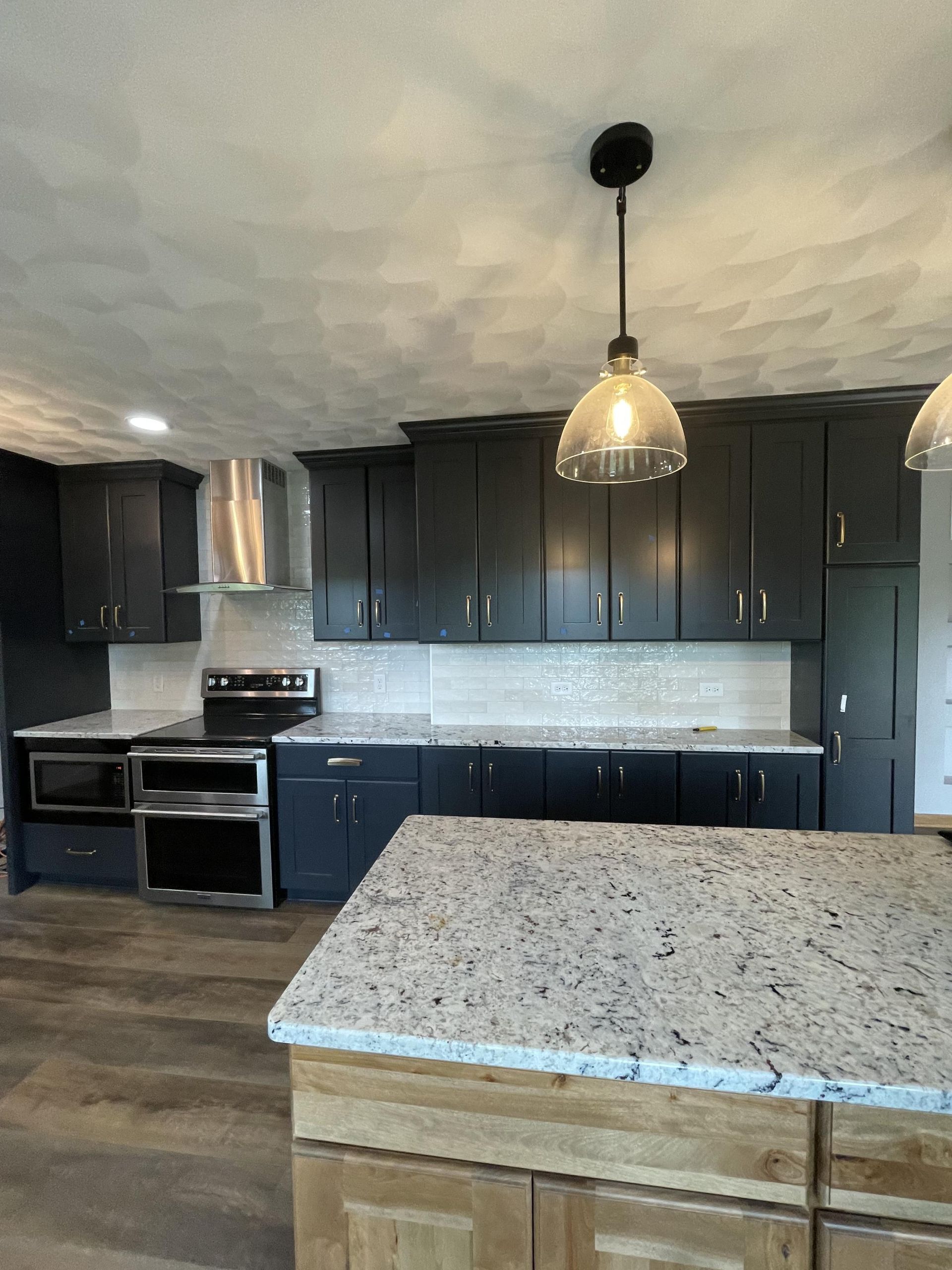 A kitchen with black cabinets and granite counter tops