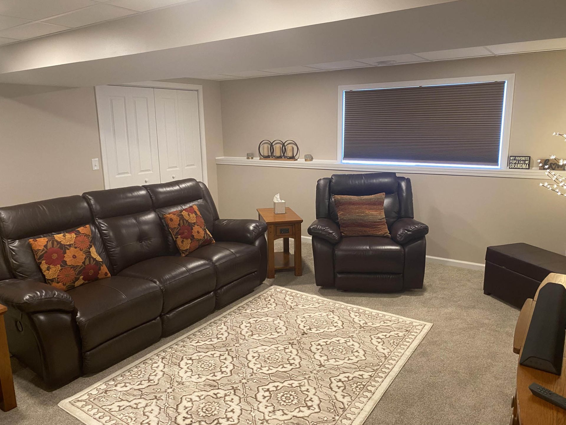 A living room with a couch , chair , table and rug.