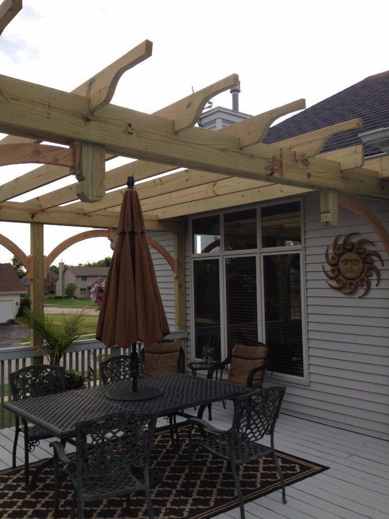 A pergola with a table and chairs underneath it