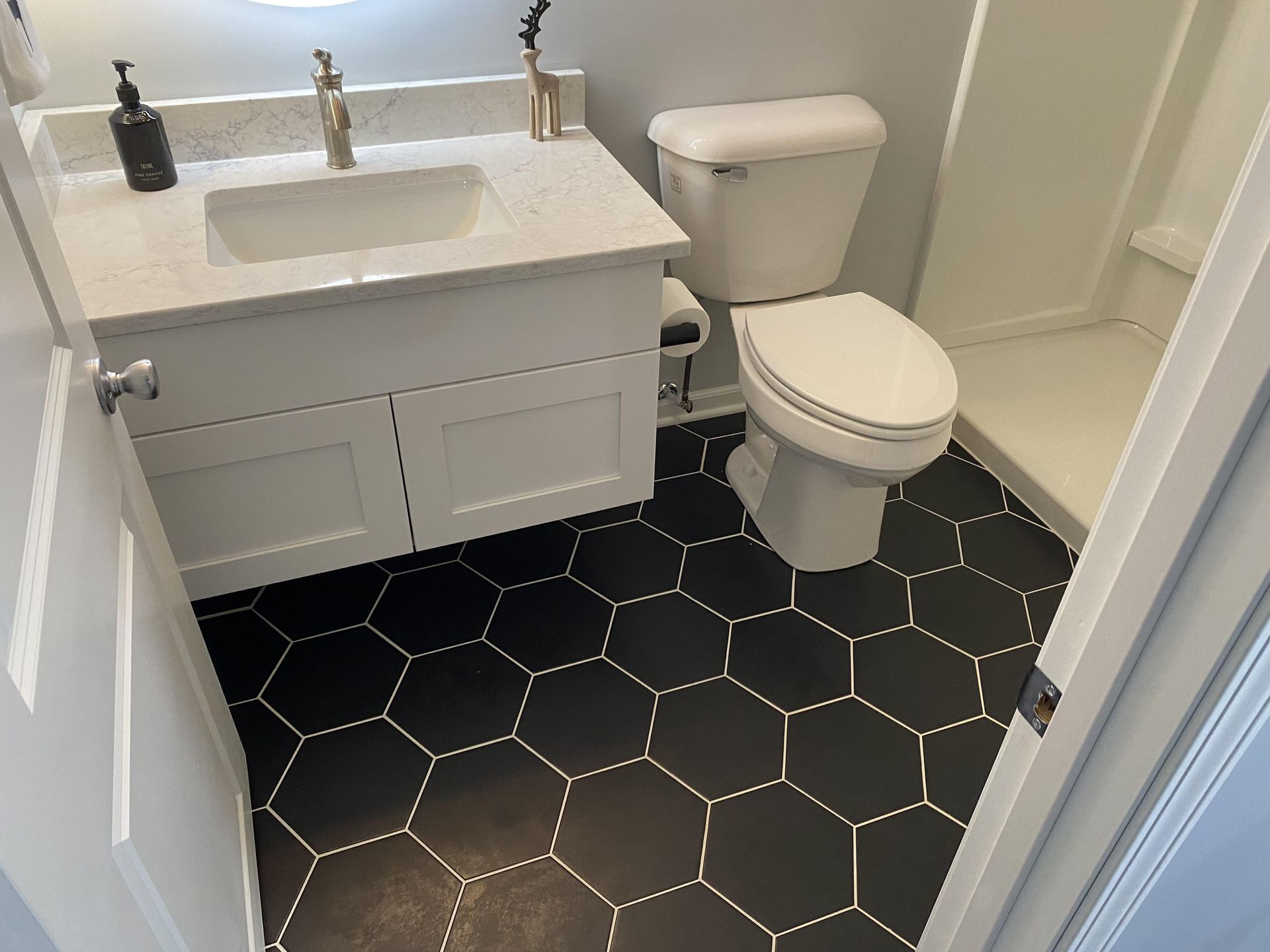 A bathroom with a sink , toilet and shower.