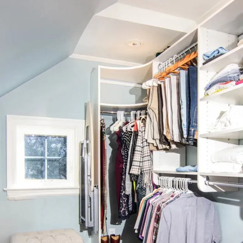 A walk in closet filled with clothes and a window