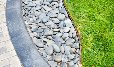 A brick walkway surrounded by rocks and grass.