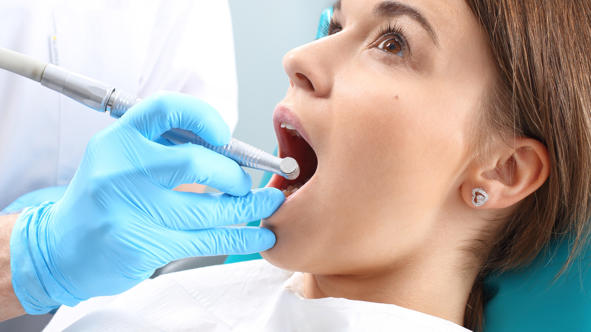 A woman is having her teeth examined by a dentist.