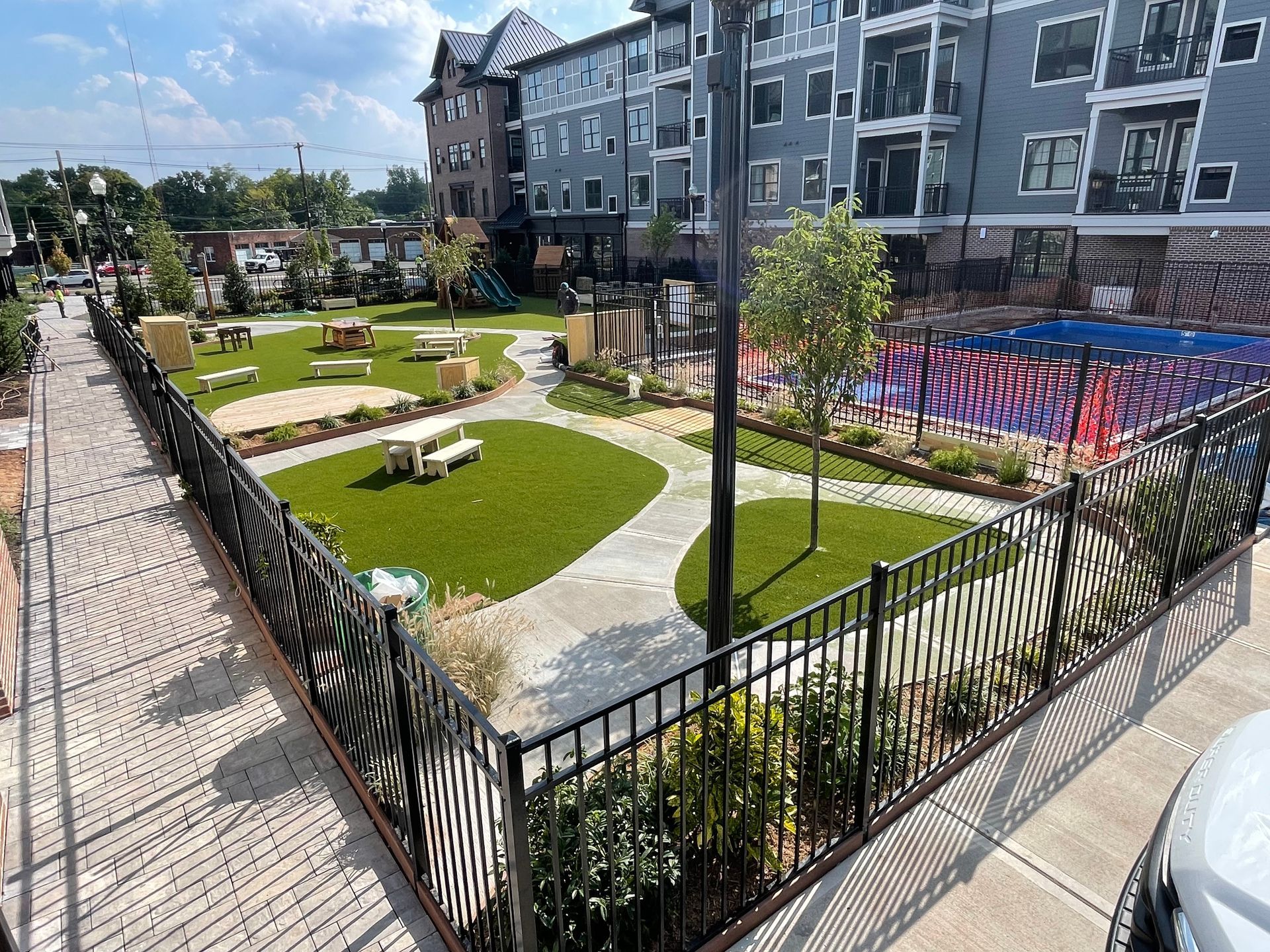 A man is standing in the middle of a driveway next to a house.