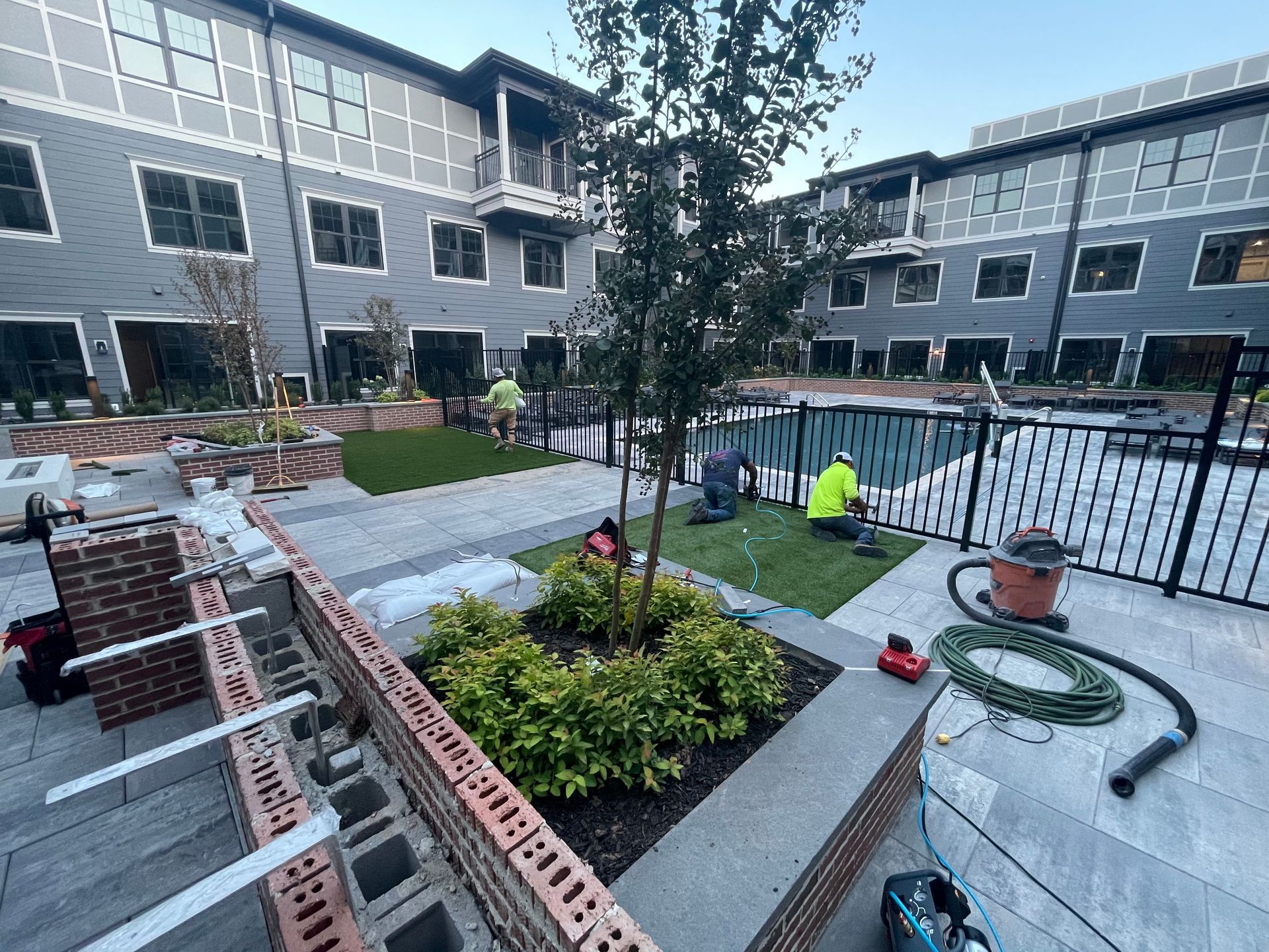 A group of people are working on a fence in front of a building.