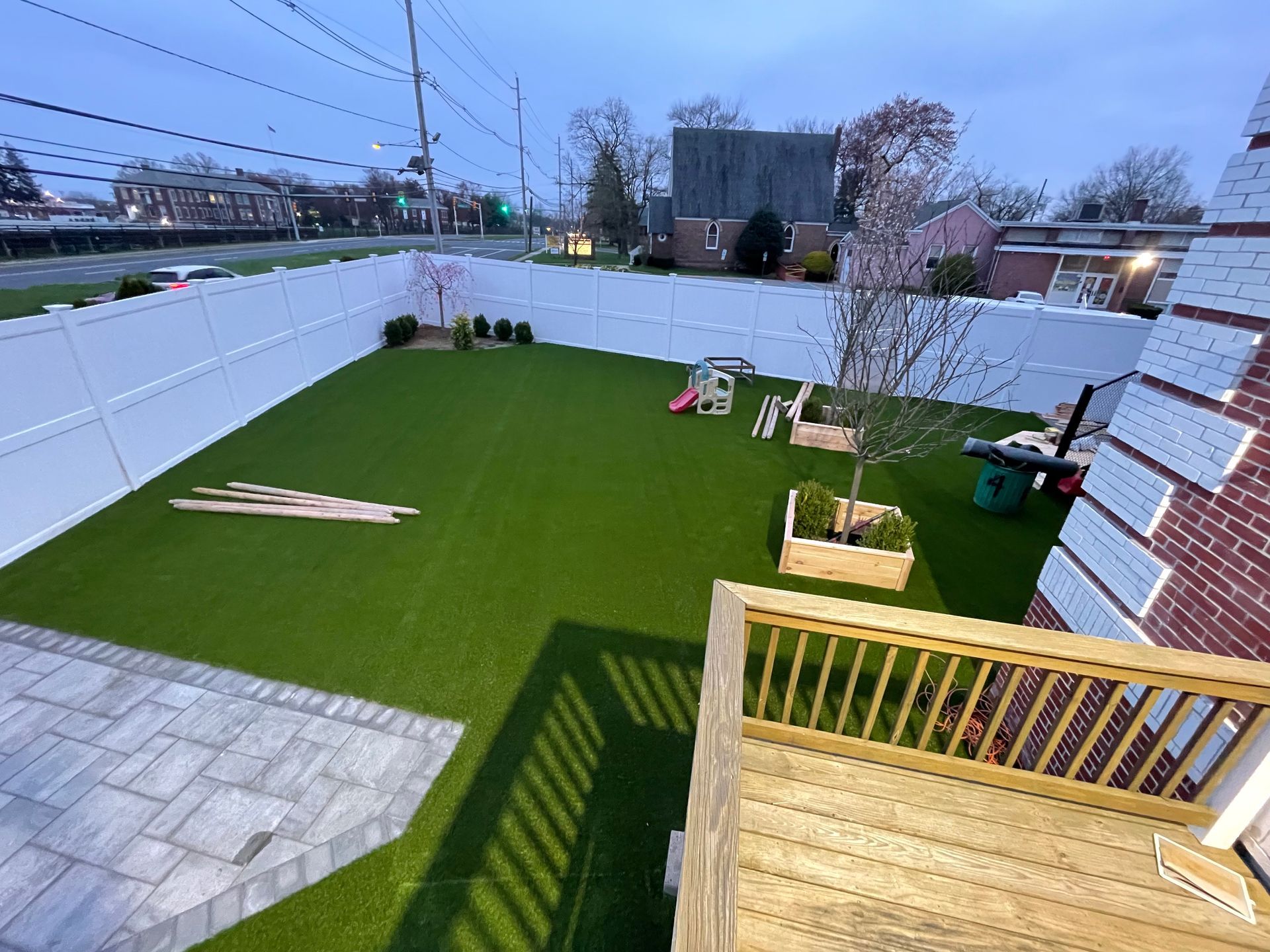 An aerial view of a backyard with a deck and a fence.