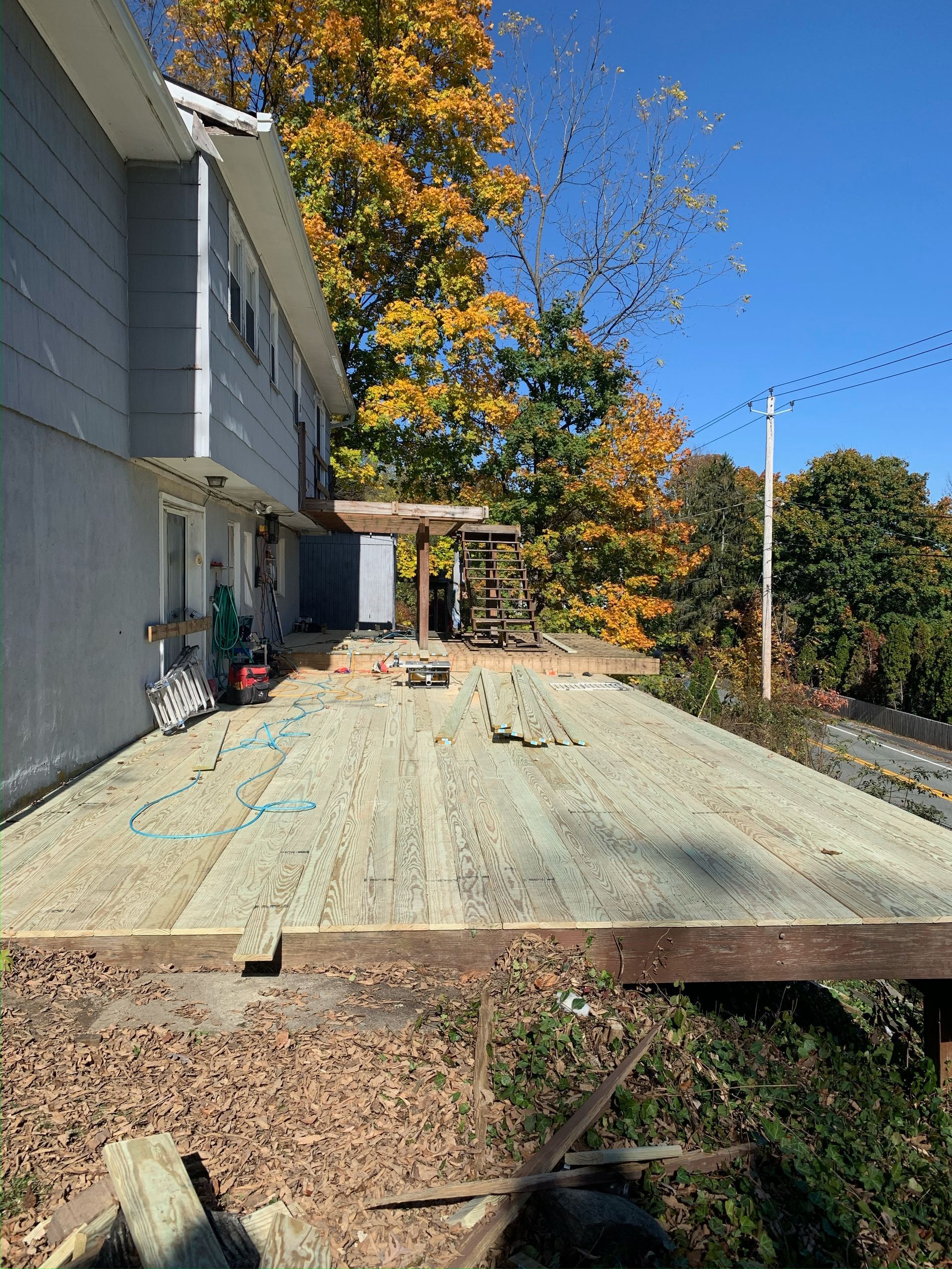 A large wooden deck is being built in front of a house.