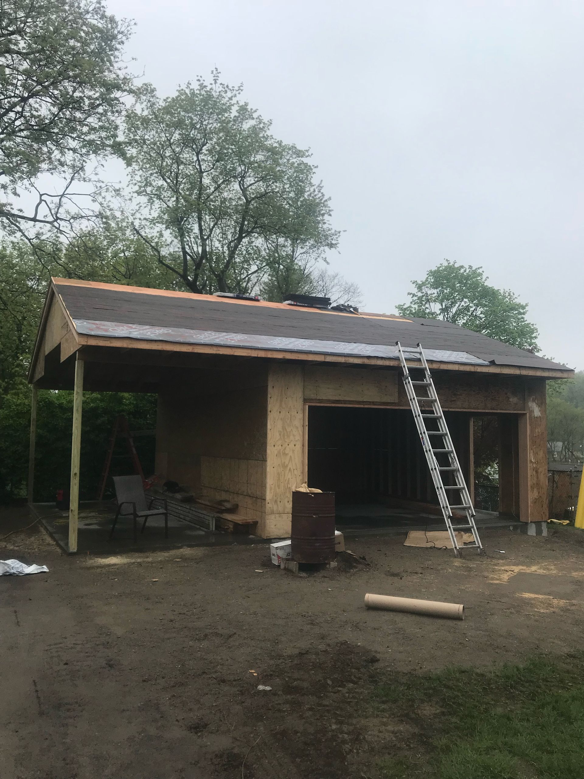 A garage under construction with a ladder on the roof