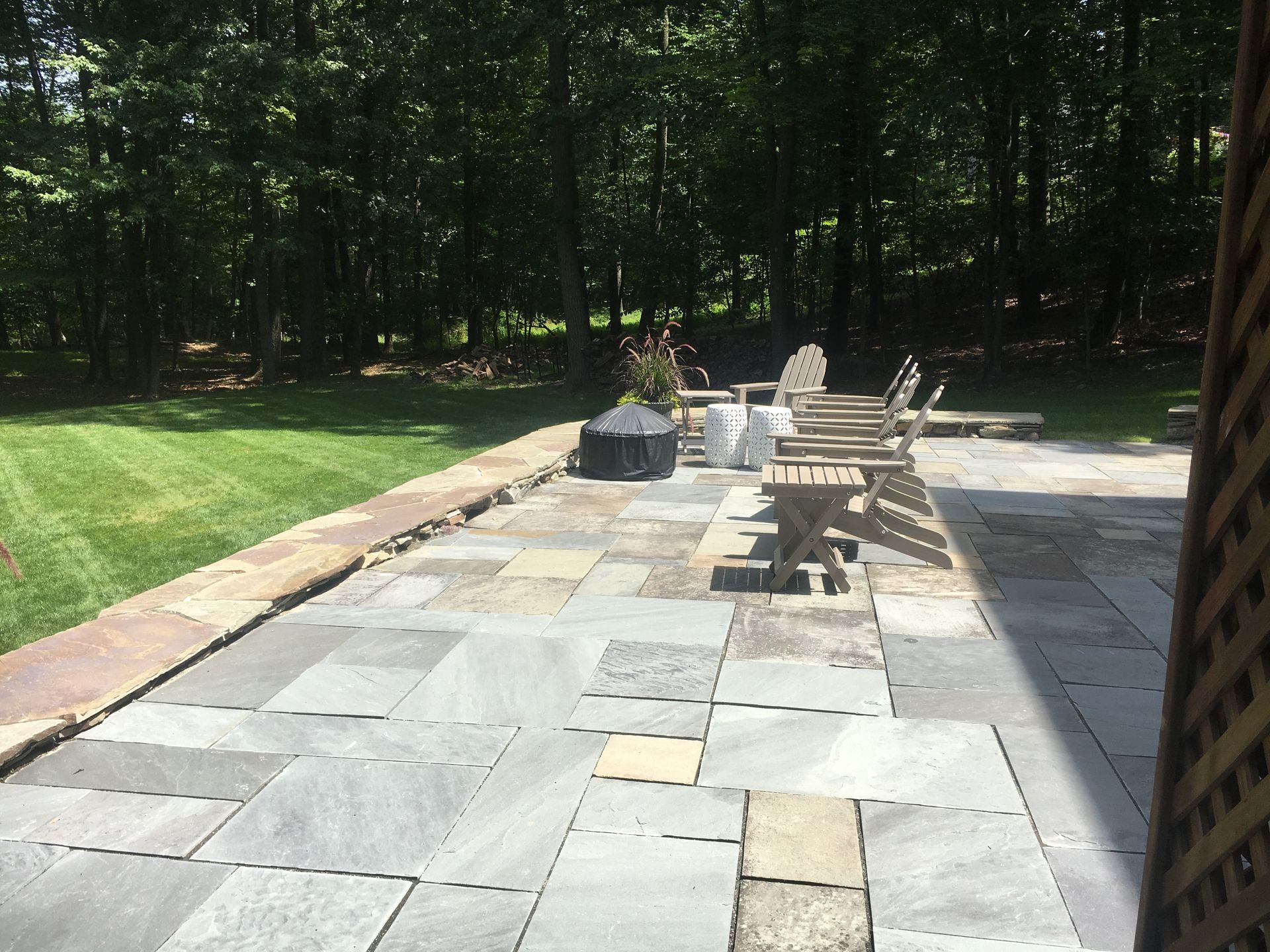 A patio with chairs and a fire pit in the backyard