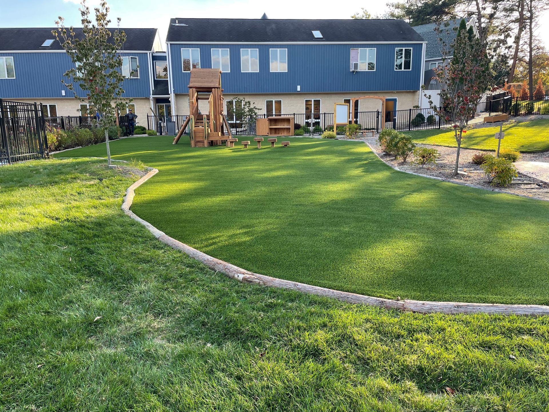 A man is standing in the middle of a driveway next to a house.