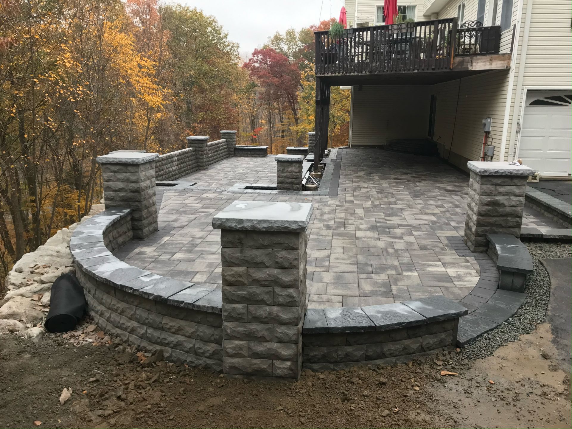 A man is spreading asphalt on a road with a shovel.
