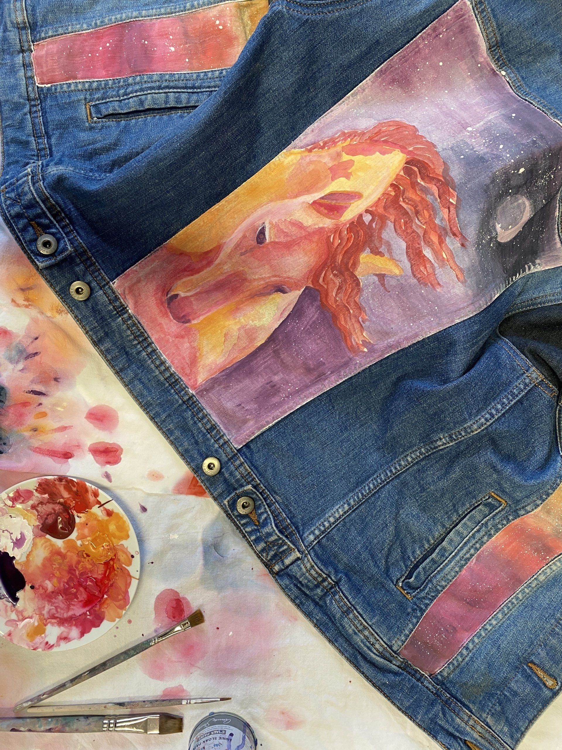 Eine Jeansjacke mit einem aufgemalten Pferdemotiv.