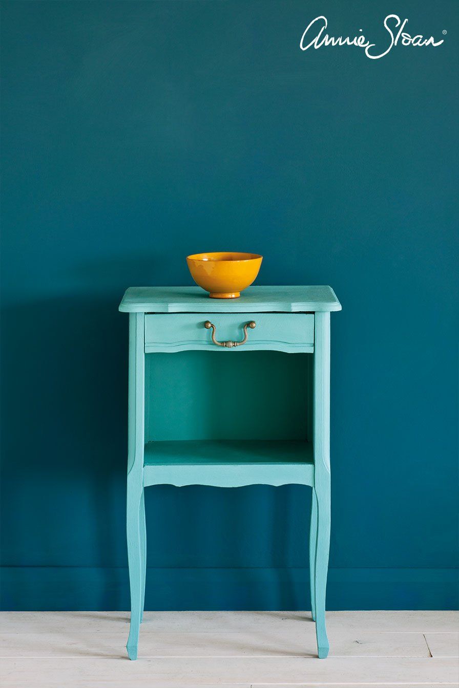 Ein blauer Tisch mit einer gelben Schüssel darauf vor einer blauen Wand.