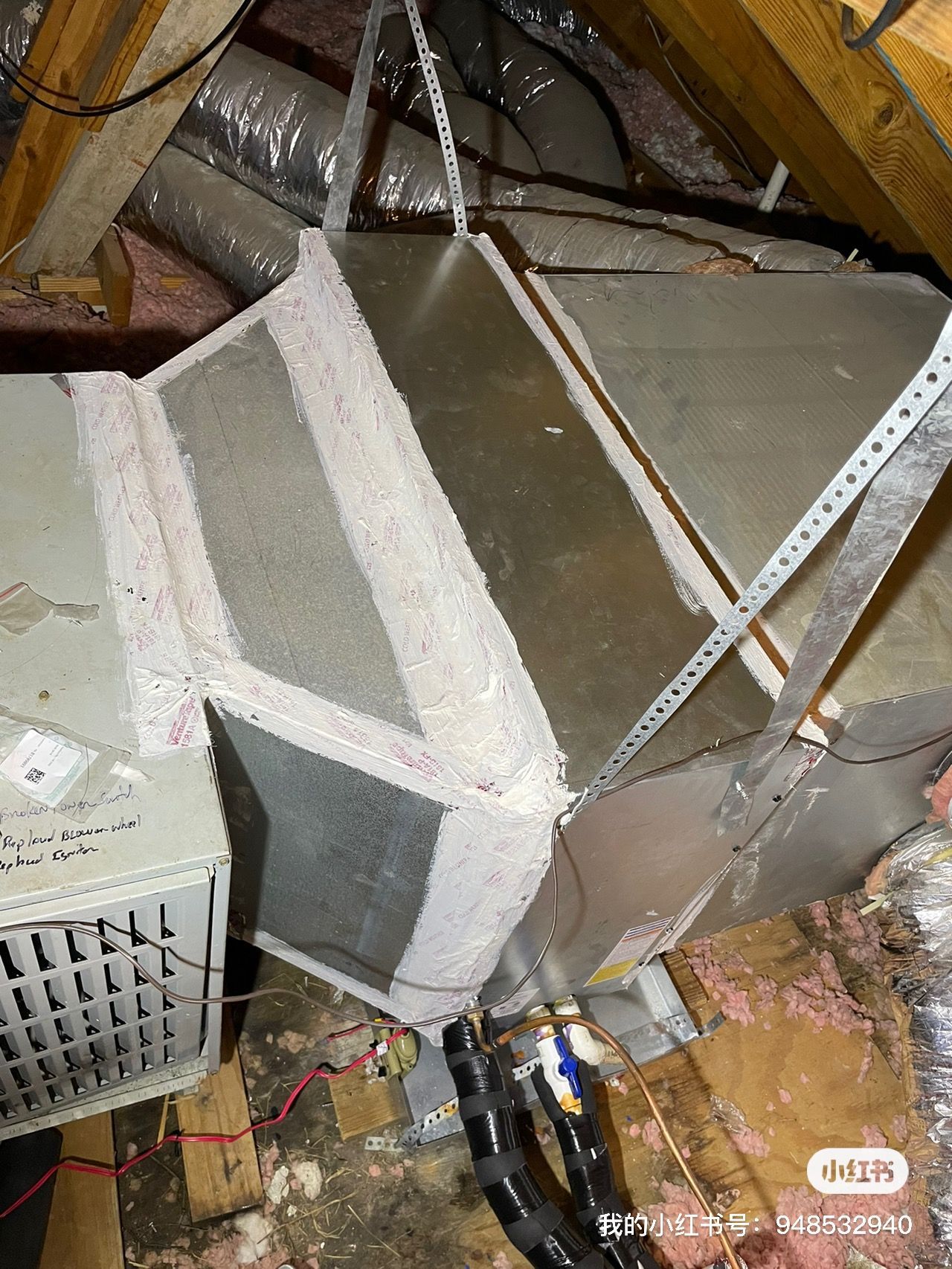 HVAC ductwork in an attic. Metal ducts are connected with taped seams, supported by metal straps. 