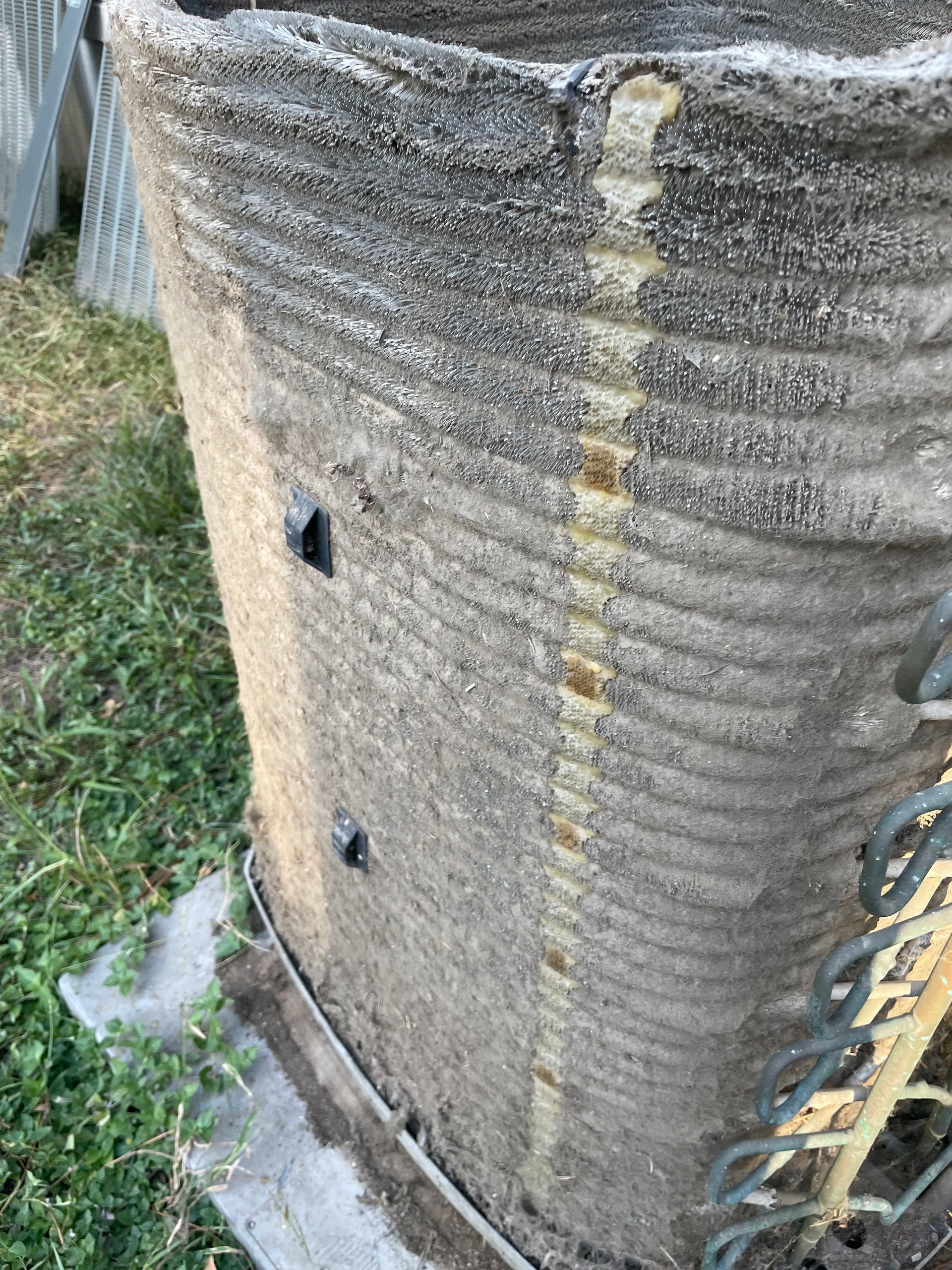 Concrete cylindrical structure, weathered texture with rectangular openings.