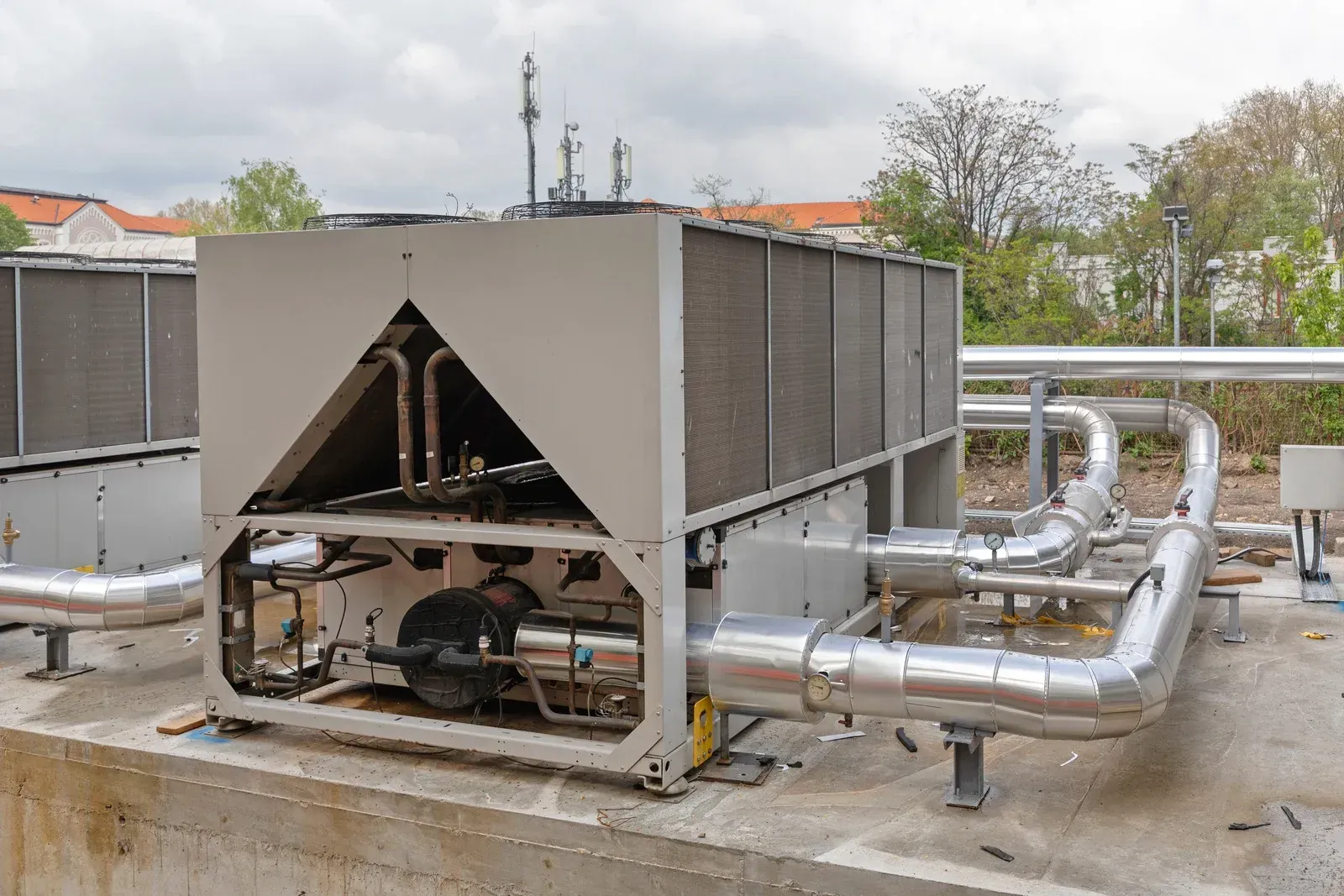 Large industrial chiller unit on a rooftop, with pipes and cooling components visible.