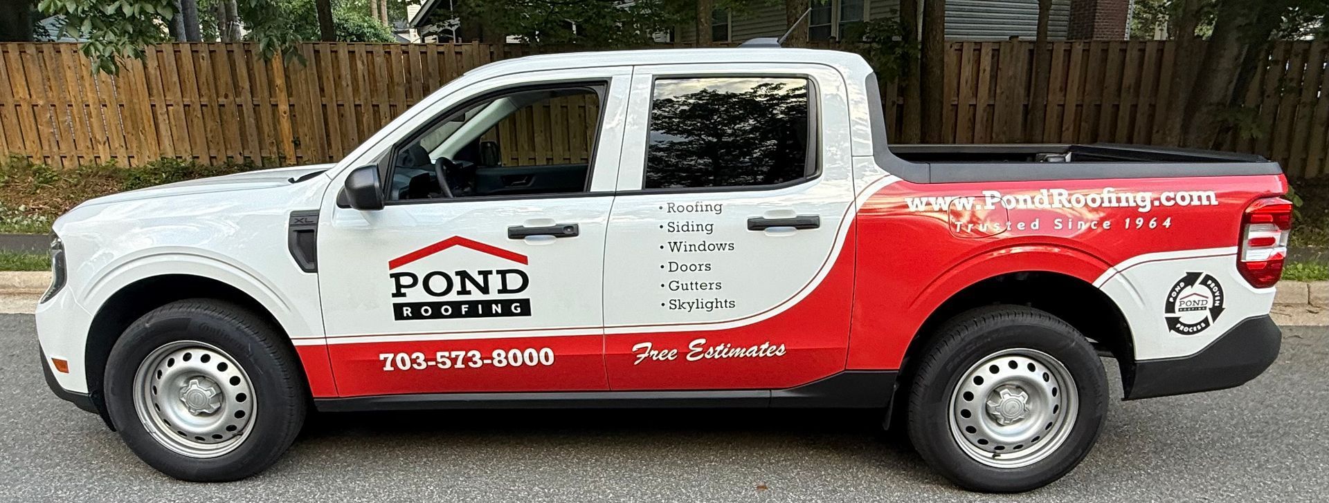 White and red Pond drywall service pickup truck parked on a street, side view