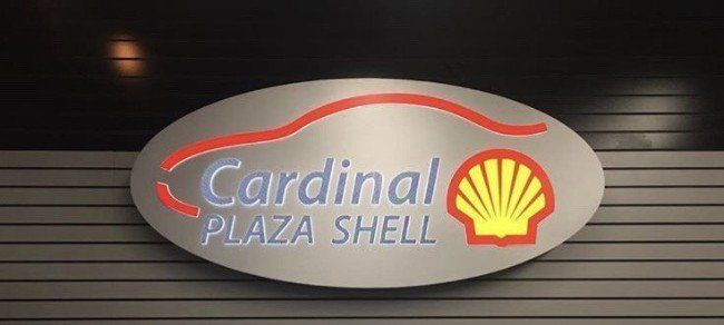 Cardinal Plaza Shell sign on a gray oval plaque with red and yellow logo