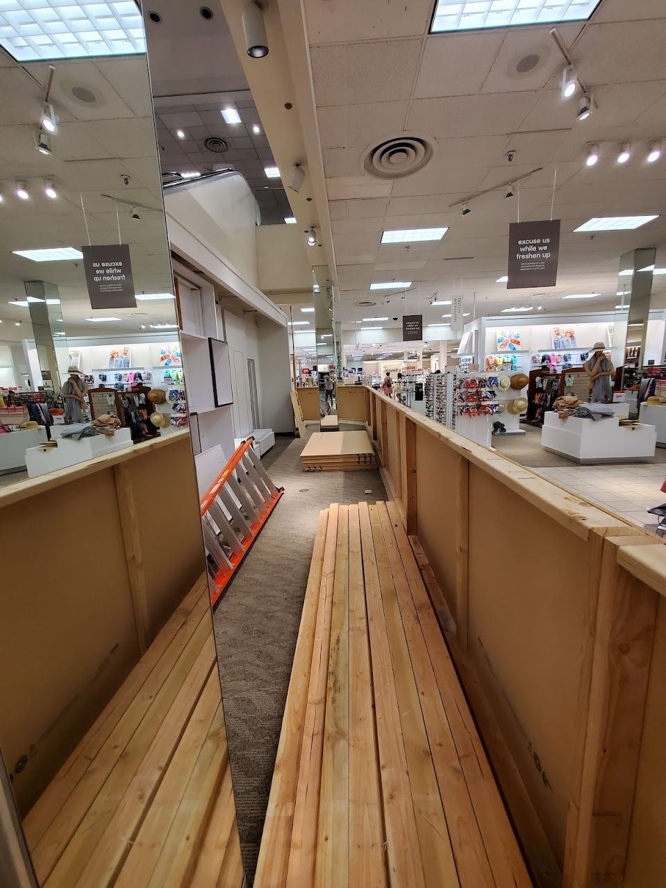 A wooden bench is sitting in the middle of a store.