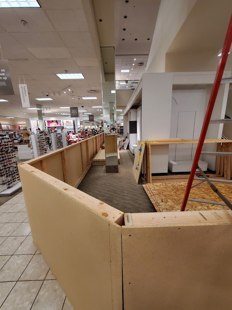 A large room in a store with a ladder in the middle of it.