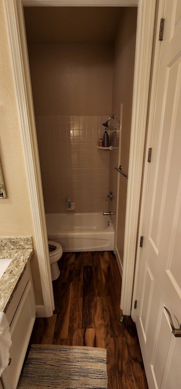 A bathroom with a bathtub , toilet and sink.