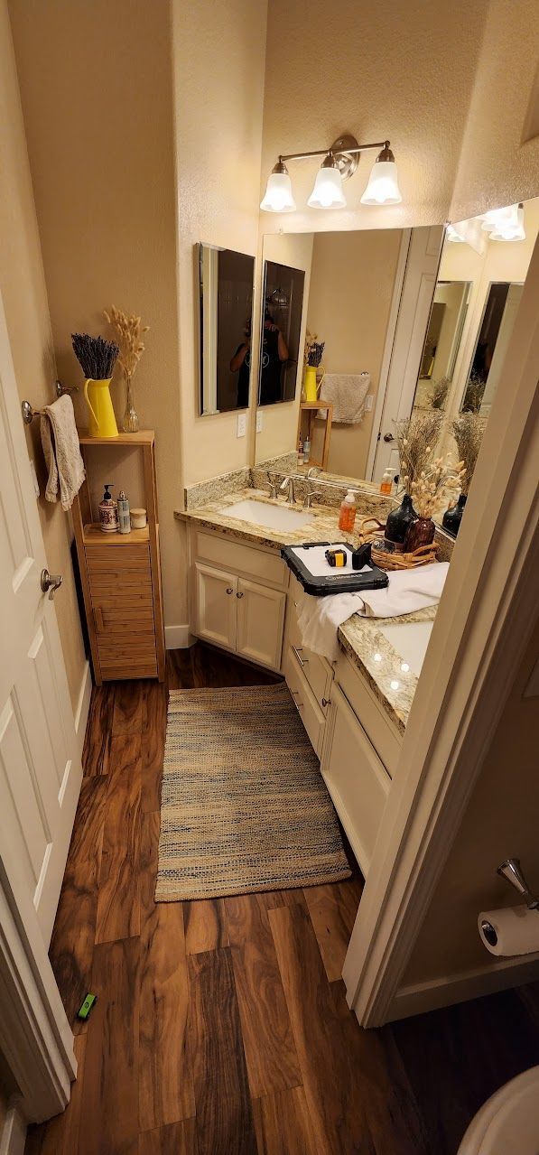 A bathroom with a sink , mirror and toilet.