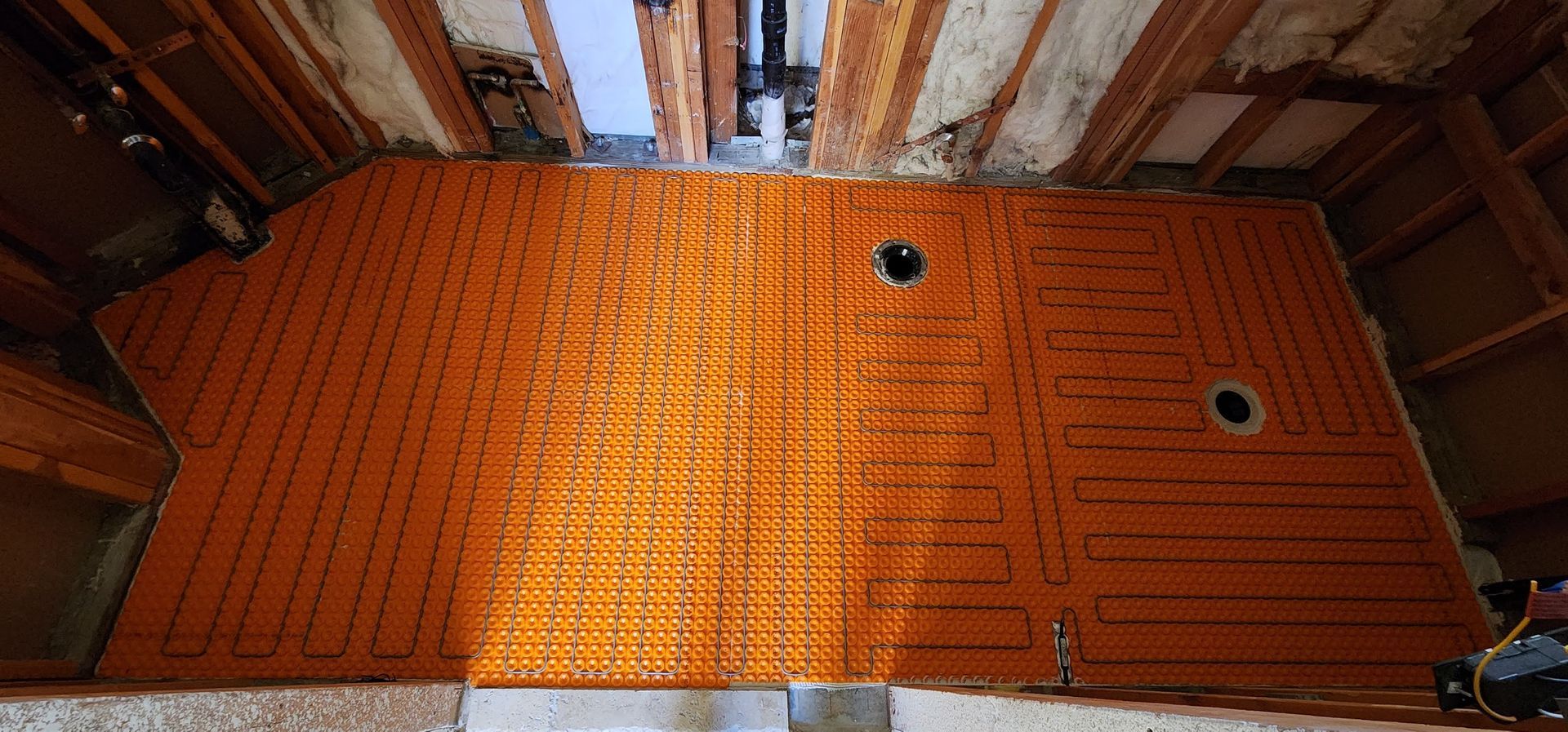 A bathroom floor with a lot of orange tiles on it.