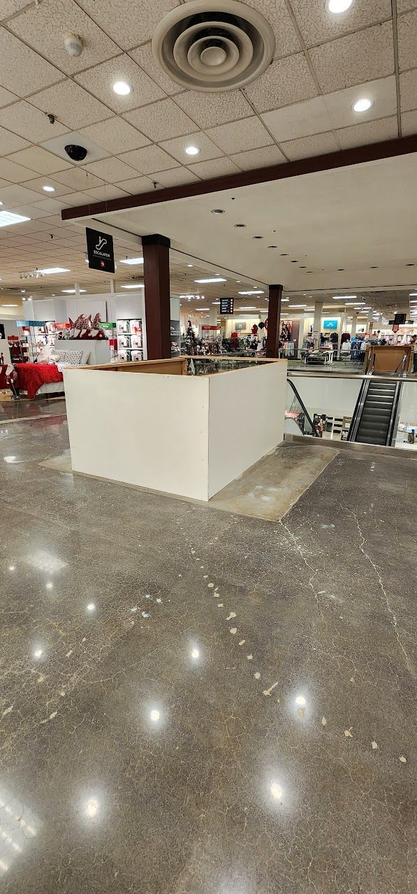 A large empty room with a ceiling fan and a lot of lights.