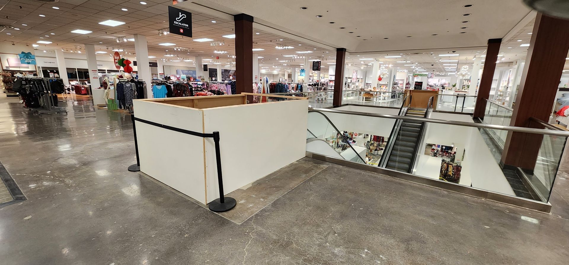 A large empty store with a staircase going up to the second floor.