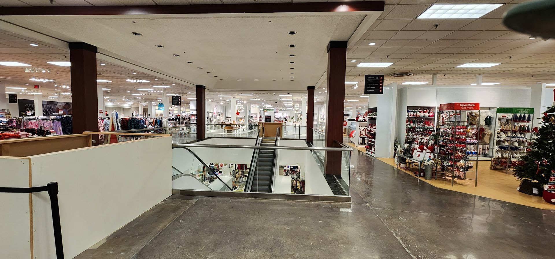 A large empty shopping mall with a christmas tree in the middle.