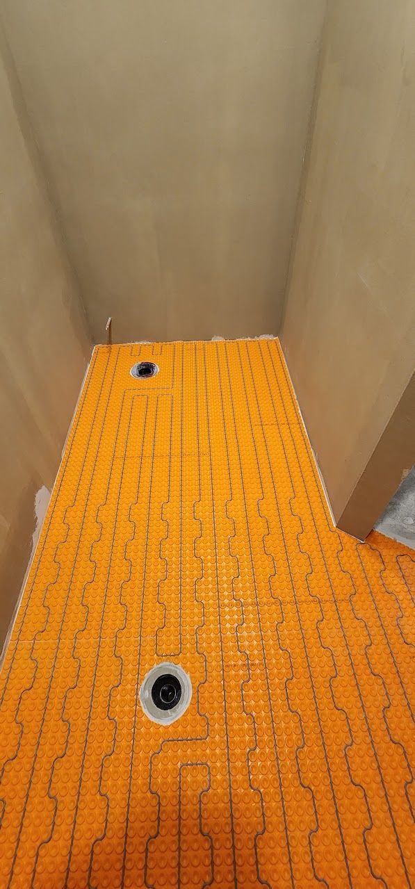 A close up of an orange tile floor in a bathroom.