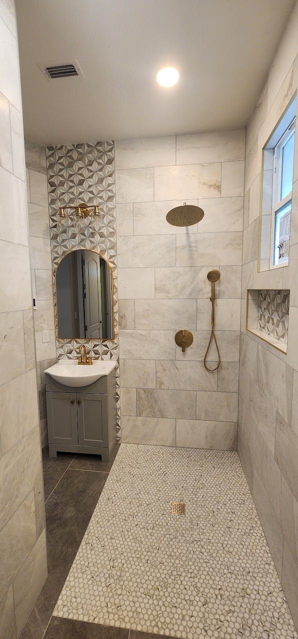 A bathroom with a walk in shower , sink and mirror.