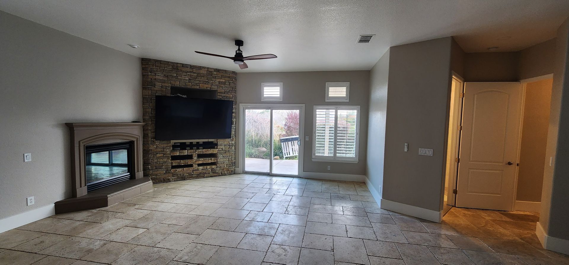An empty living room with a fireplace and a flat screen tv.