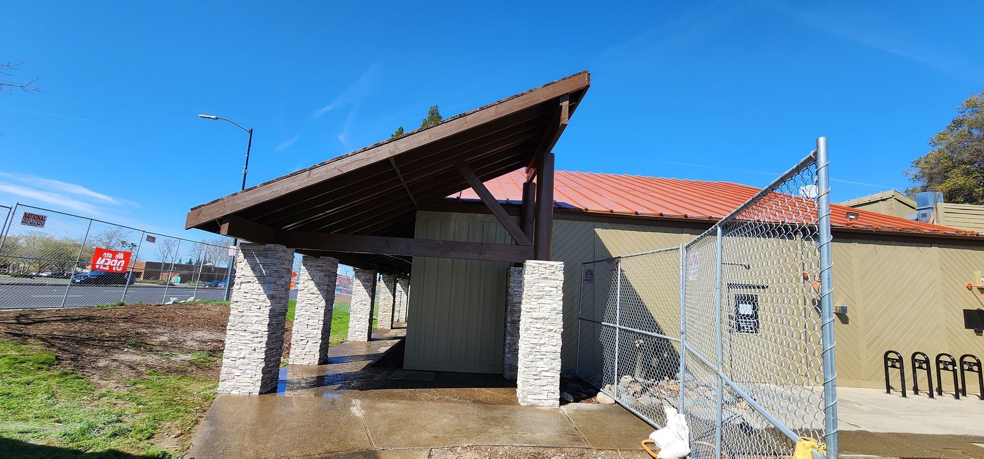 A building with a roof and a chain link fence around it