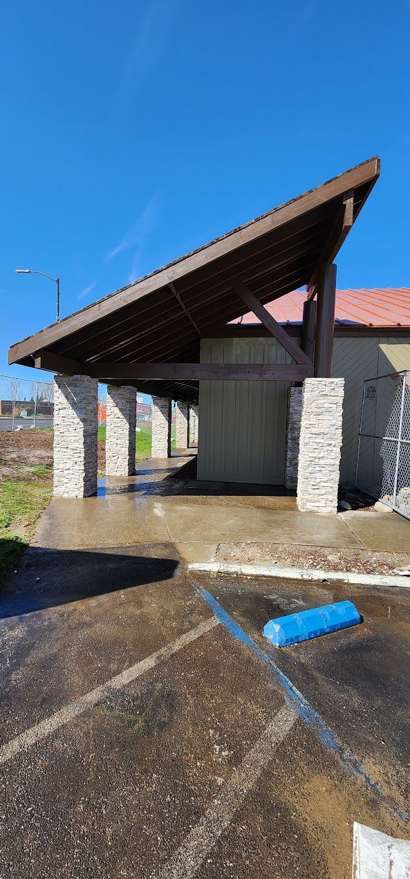 A building with a wooden roof is sitting in a parking lot.