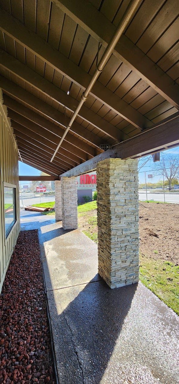 A covered walkway leading to a building with a wooden roof.
