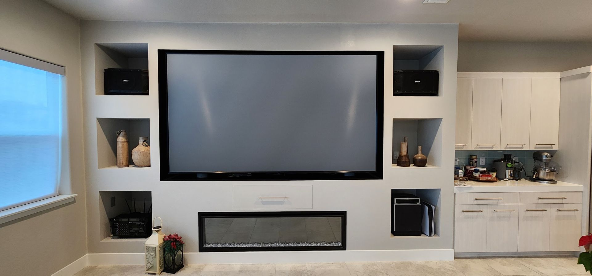 A living room with a fireplace and a large flat screen tv on the wall.