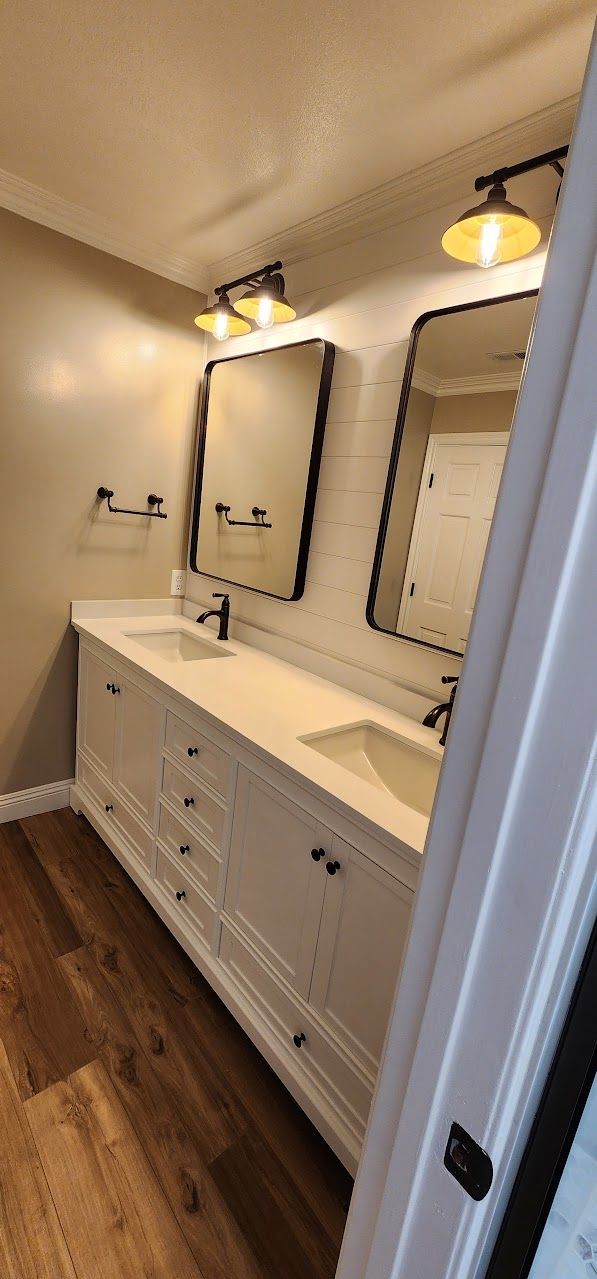 A bathroom with two sinks and two mirrors.